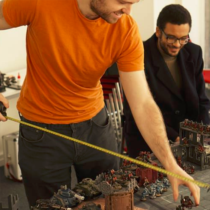 Wargames image, featuring ex-President Nigel and ex-Wargames Rep James smiling at a tape measure. And some minis.